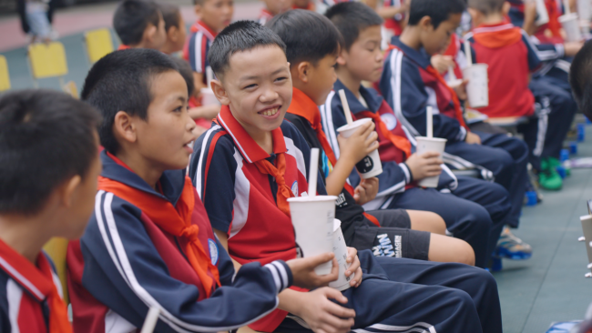 开学仪式上，学生们人手一杯古茗奶茶，这份礼物让他们笑的很开心