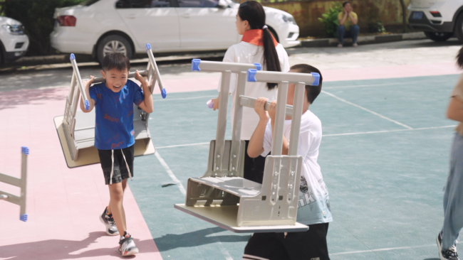 学生开心的搬运属于自己的新课桌椅